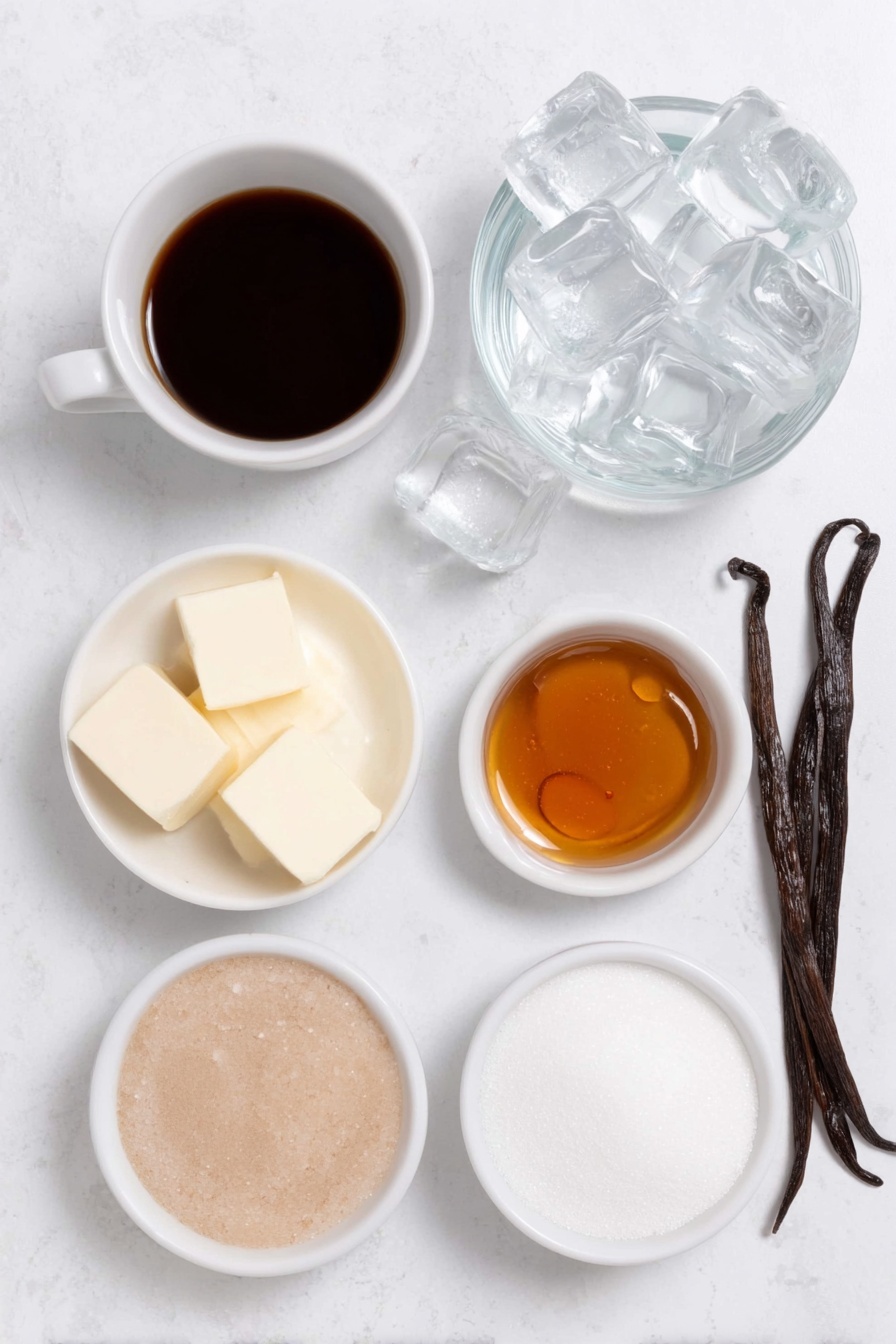 Flat lay of a small white ceramic bowl with dark brewed coffee, a few large clear ice cubes scattered nearby, a small white ceramic bowl with pale creamy half and half, a small white ceramic bowl holding amber vanilla coffee syrup glistening, a whole vanilla bean pod with glossy black seeds visible beside it, a small white ceramic bowl of clear water, and a small white ceramic bowl of white granulated sugar, all arranged in perfect symmetry and realistic proportions, placed on a clean white marble surface, soft natural light, photo taken with an iPhone, professional food photography style, fresh ingredients, white ceramic bowls, no bottles, no duplicates, no utensils, no packaging --ar 2:3 --v 7 --p m7354615311229779997
